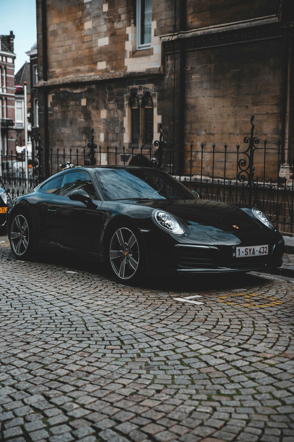 black porsche 911 parked on sidewalk during daytime