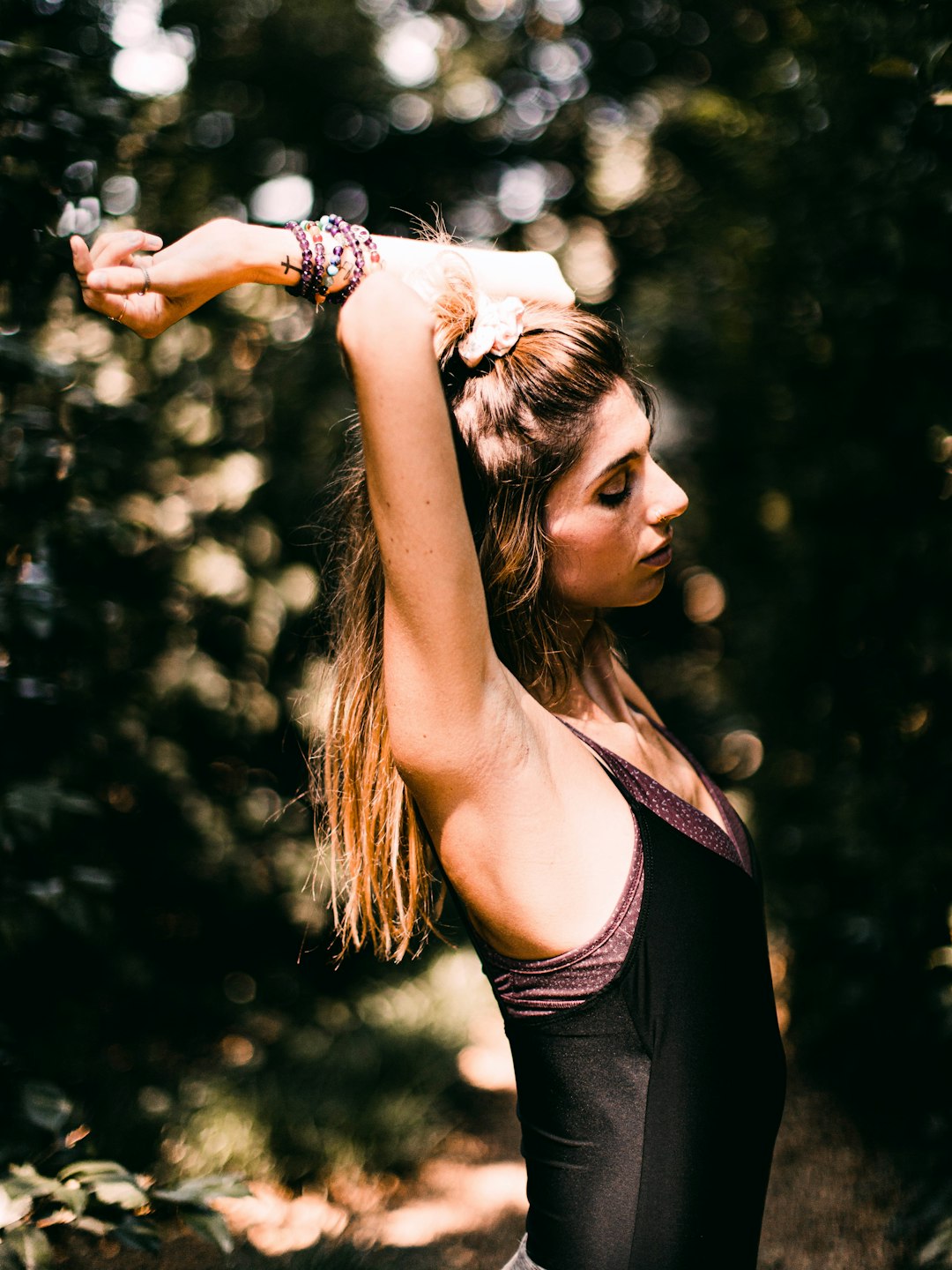 woman in black tank top holding her hair