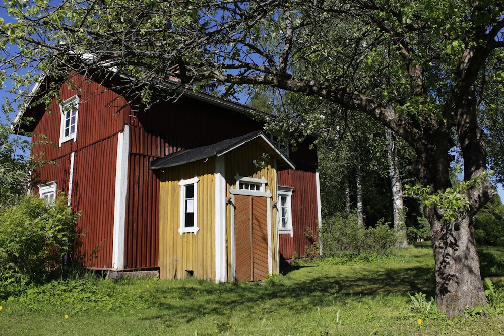 red and white wooden house near green trees during daytime