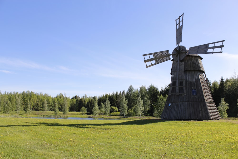 moulin à vent noir sur un champ d’herbe verte pendant la journée