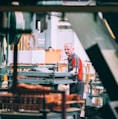 man in orange polo shirt standing in front of table