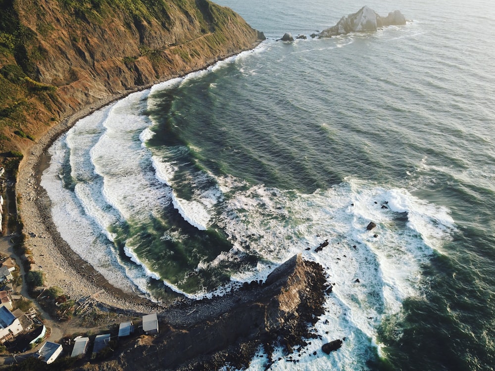 aerial view of ocean waves crashing on shore during daytime