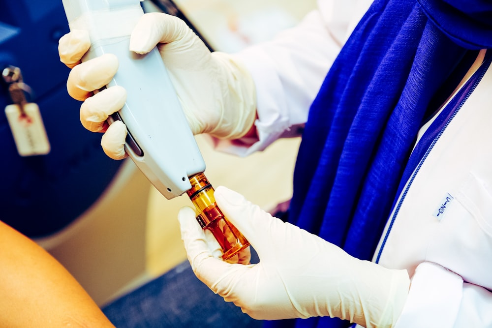 person holding white and silver tube type vape