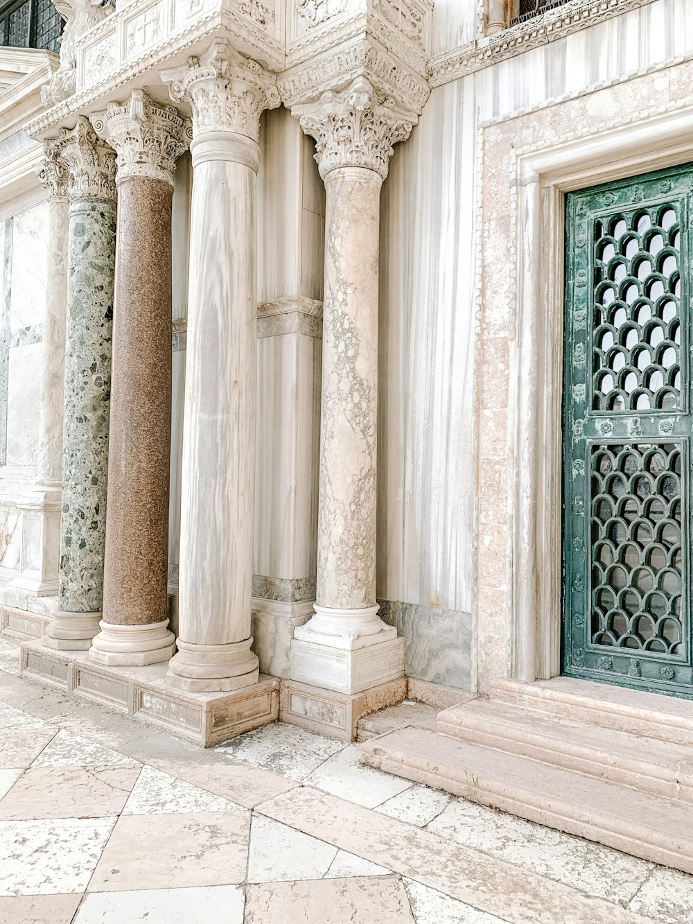 검은 금속 창 근처의 흰색 콘크리트 기둥