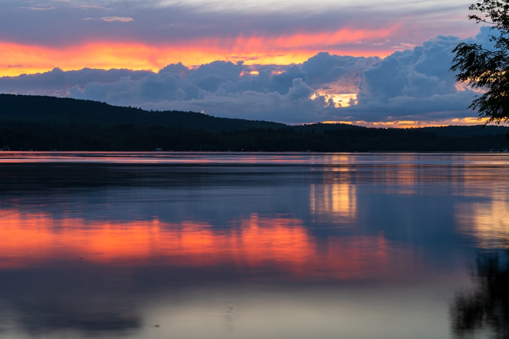 corpo d'acqua vicino alla montagna durante il tramonto