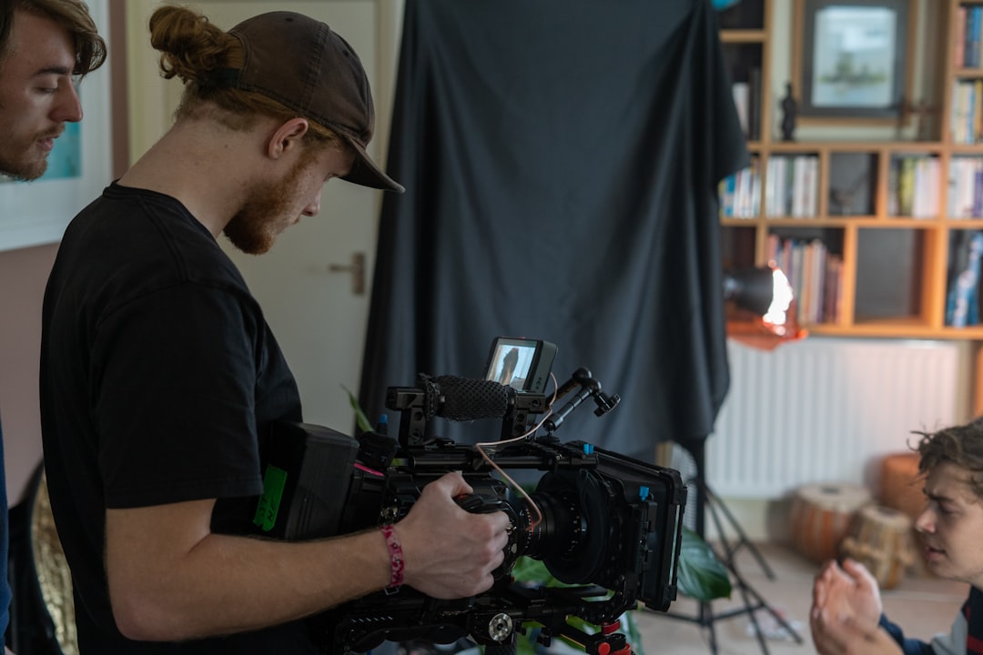 man in black crew neck t-shirt using black video camera