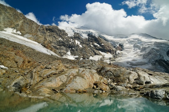 snow covered mountain near body of water during daytime in Hohsaas Switzerland