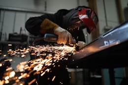 person in black jacket holding brown wooden rolling pin