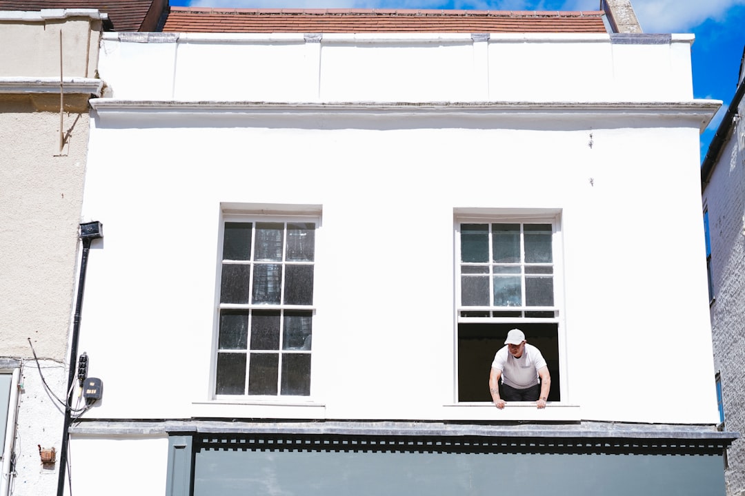 woman in white long sleeve shirt sitting on window during daytime