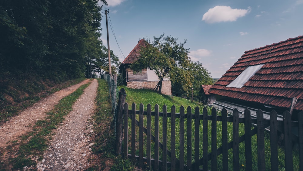 brown and white wooden house near green trees under blue sky during daytime