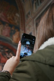 woman in white fur jacket holding black iphone 5