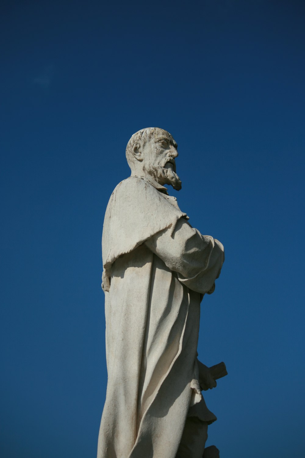 Estatua de hormigón blanco bajo el cielo azul durante el día