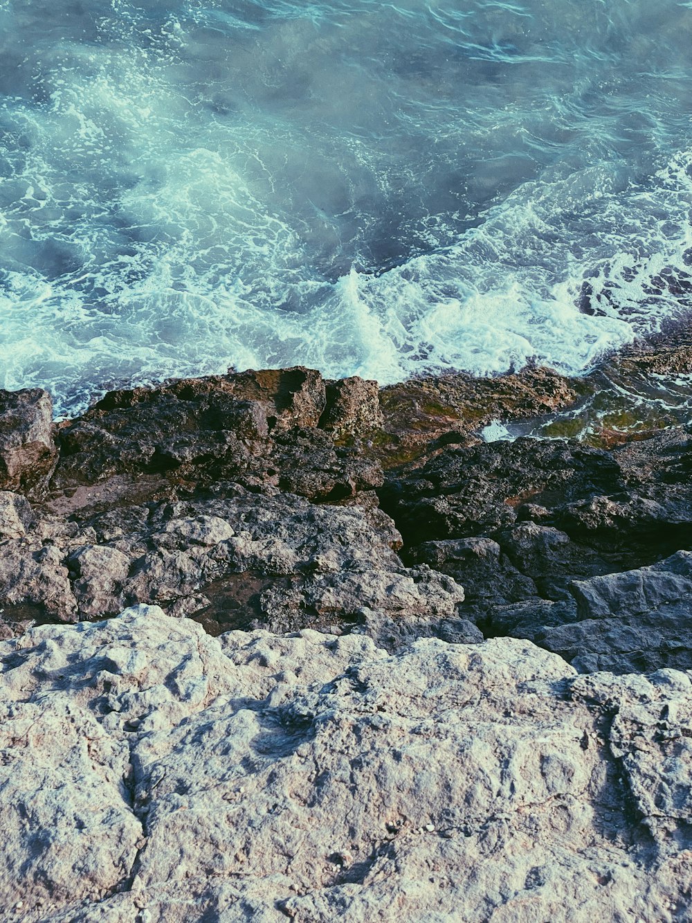 ocean waves crashing on rocky shore during daytime