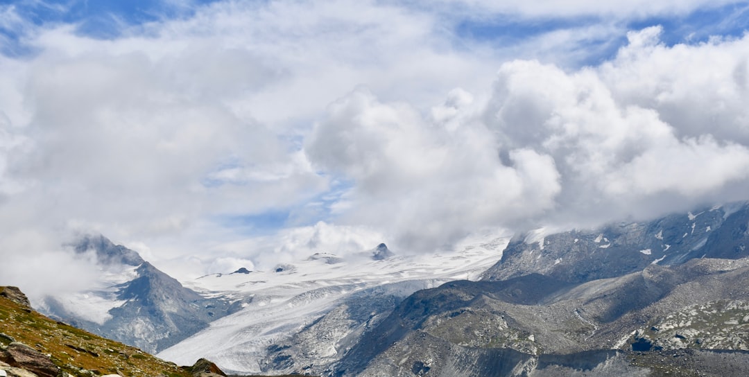 snow covered mountain under white clouds during daytime