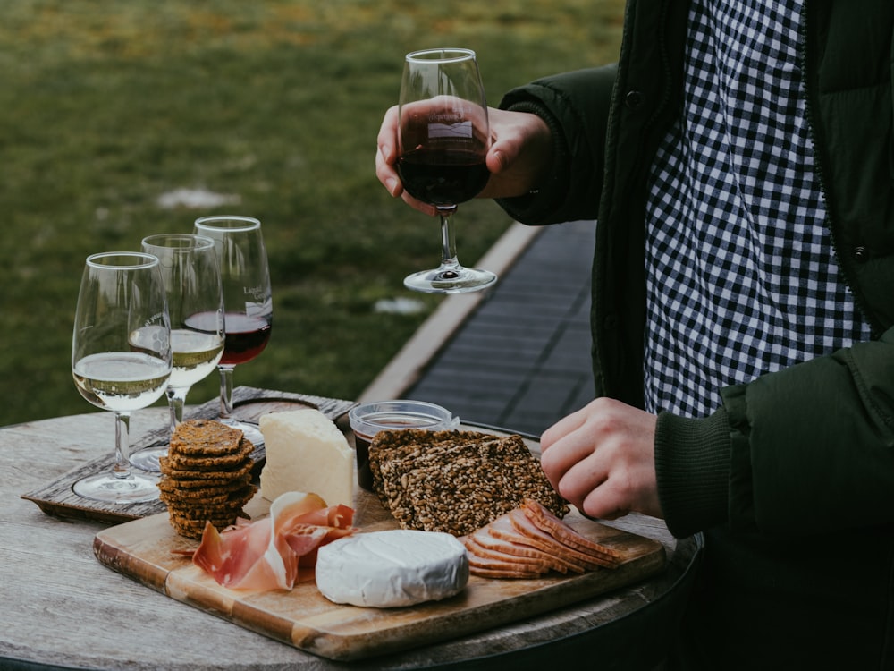 person holding wine glass with red wine