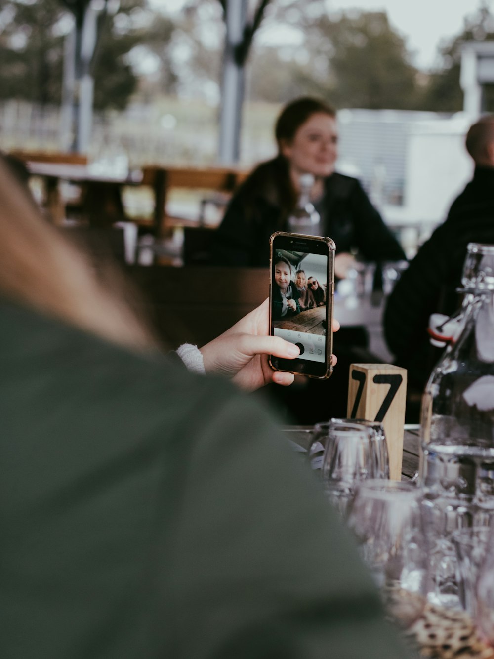 woman in black shirt holding black smartphone