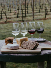 Tray of local wines and cheeses set on a rustic wooden table.
