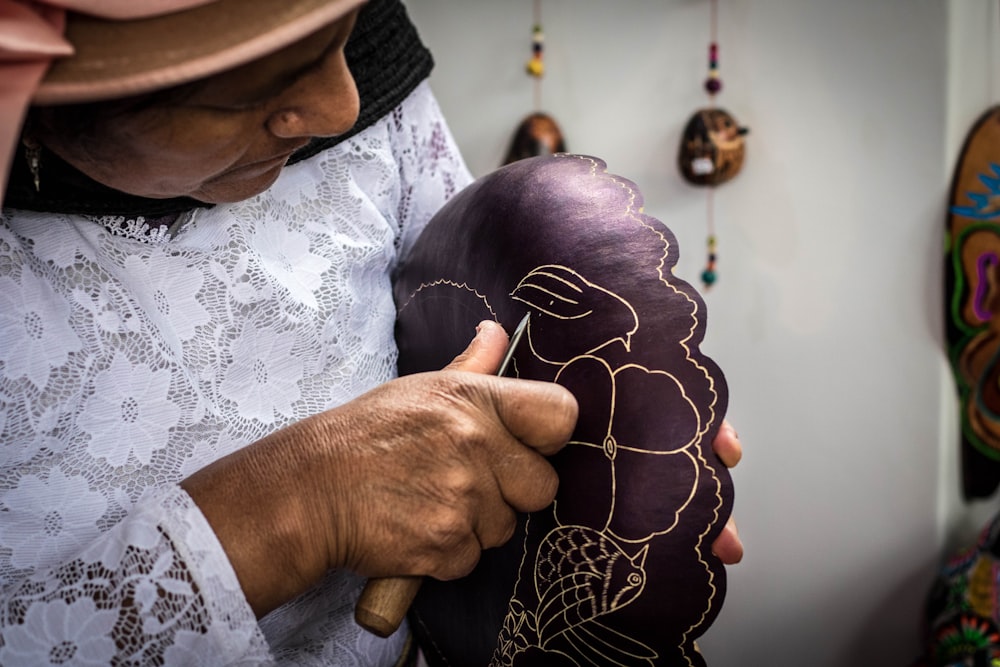 man in white and black long sleeve shirt with brown hat holding purple and white floral