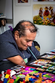 Santiago engaged in a creative hobby, showing determination despite physical challenges.