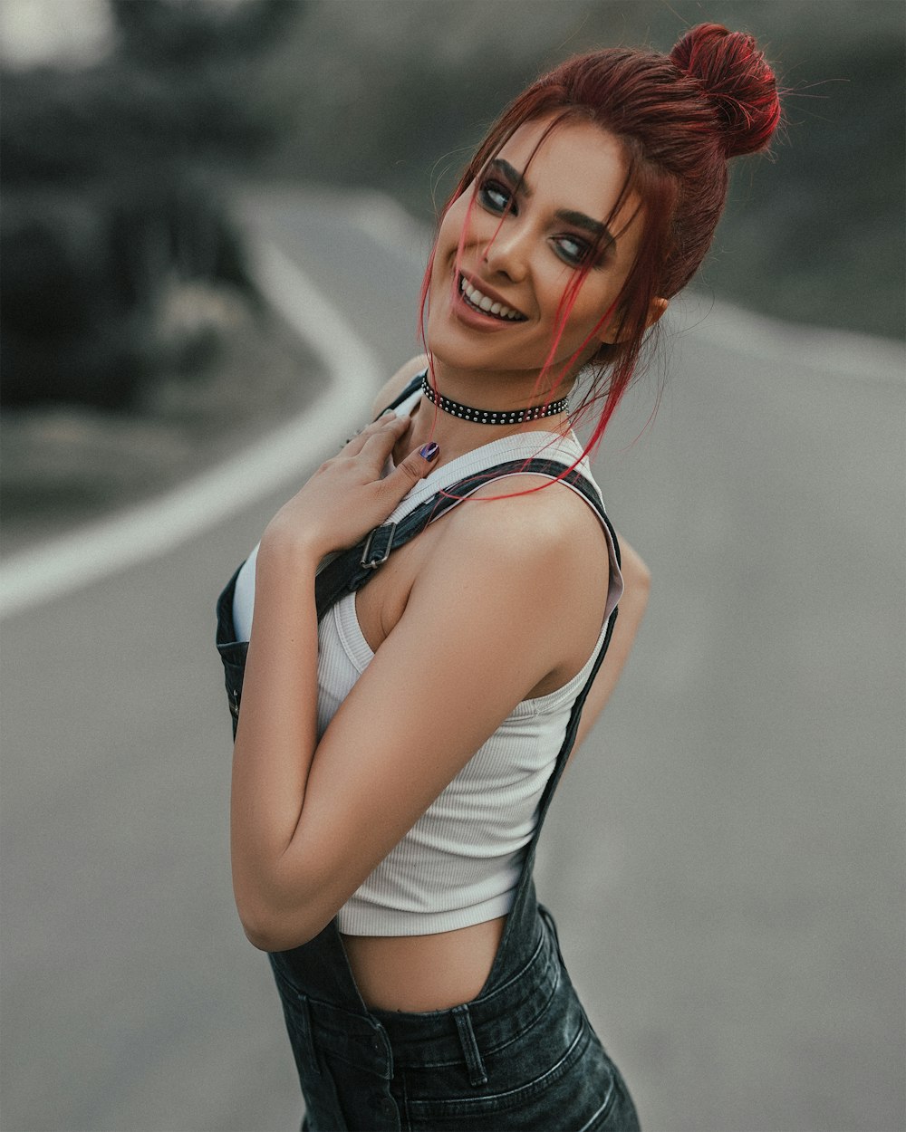 woman in white tank top and black denim shorts smiling