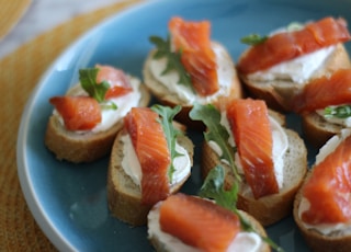 sliced tomato and green leaf vegetable on blue ceramic plate