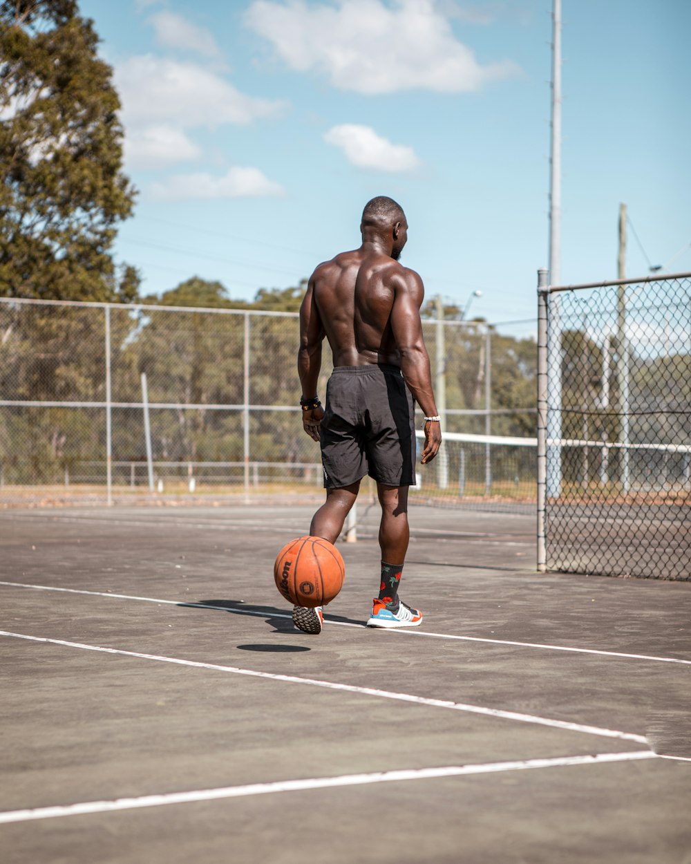 man in black shorts running on basketball court