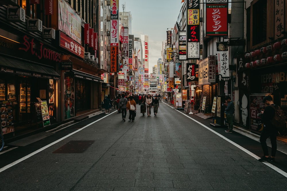 people walking on street between high rise buildings during daytime