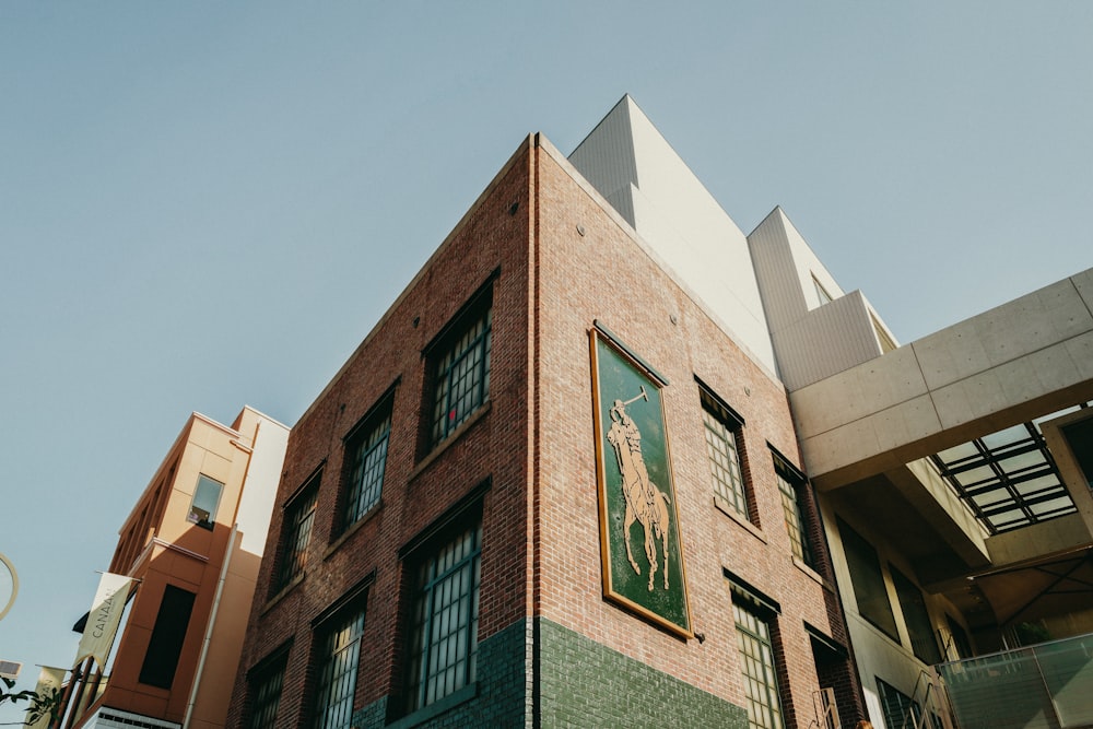 Un edificio alto de ladrillo con un letrero verde en el costado