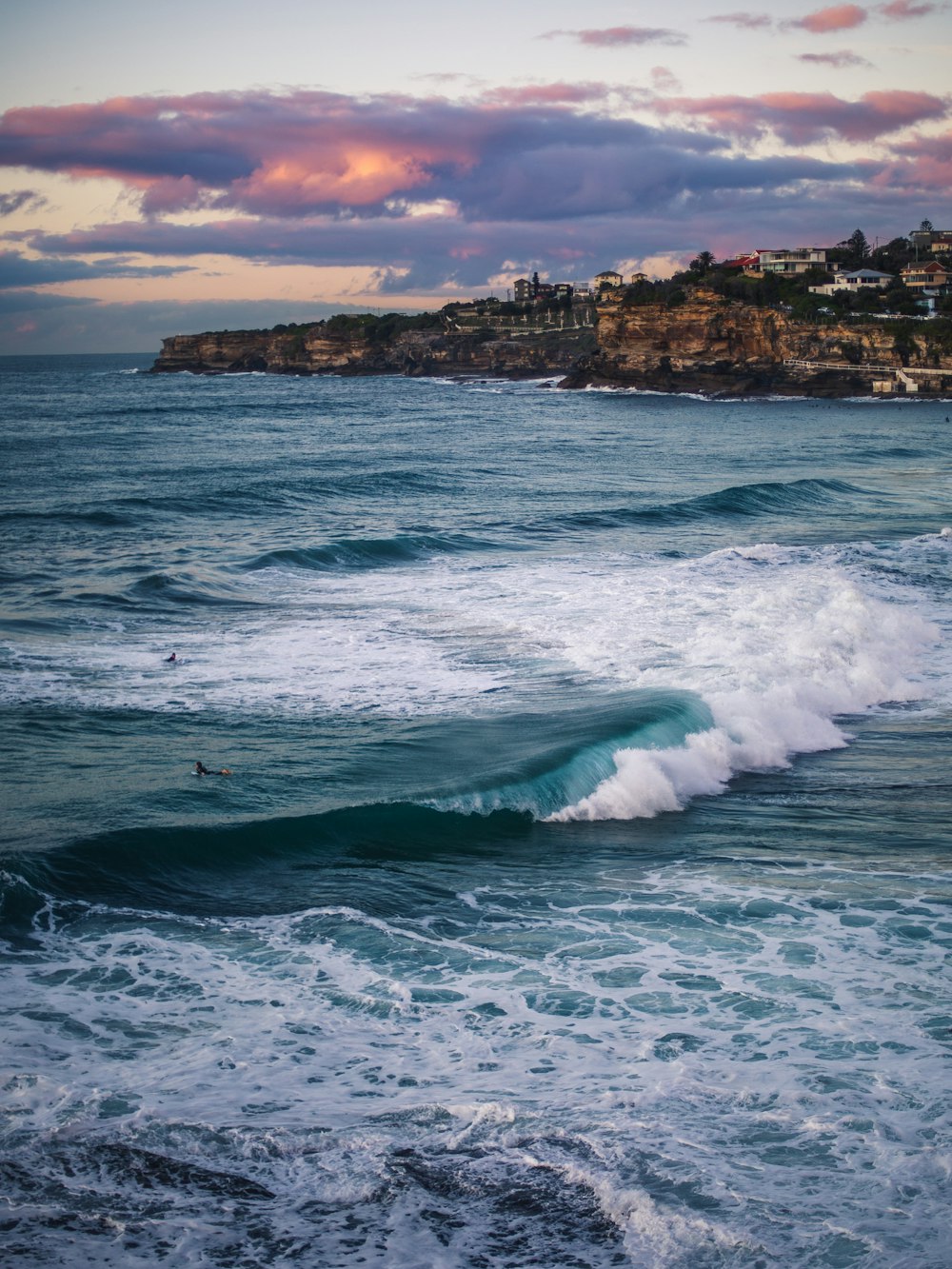 ocean waves crashing on rocky shore during daytime