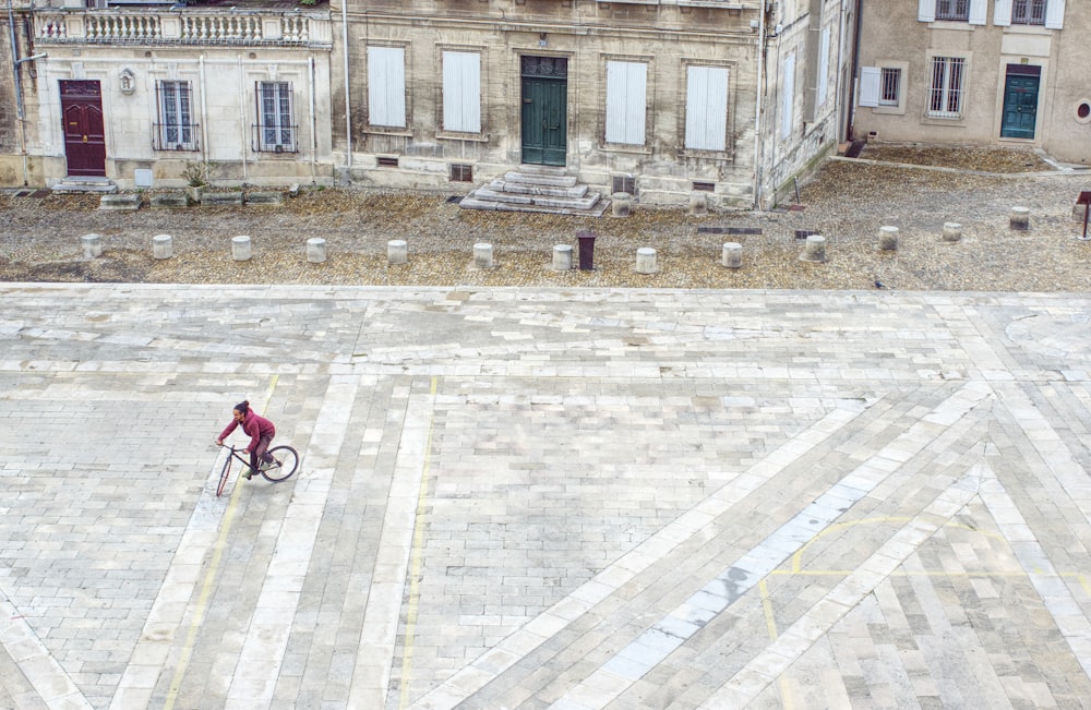 red bicycle parked on sidewalk near building during daytime