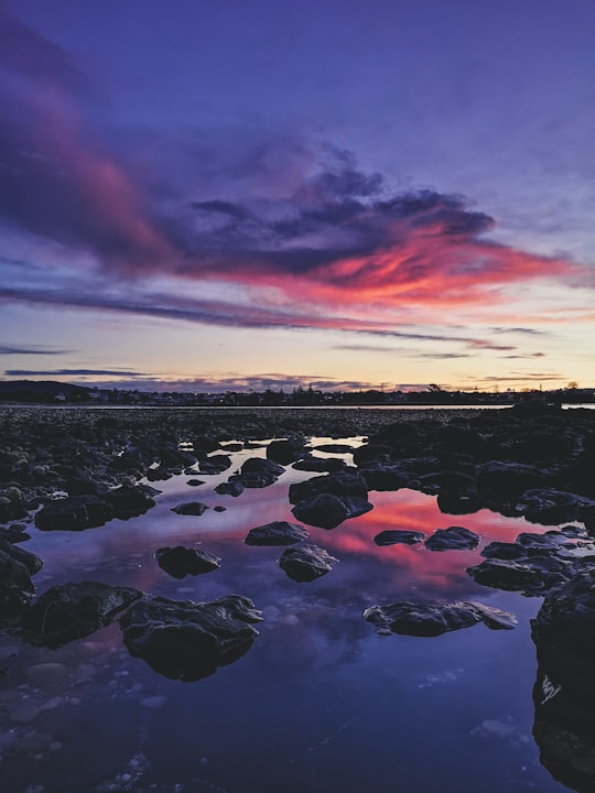 rocks on water under cloudy sky during sunset in Devonport TAS Australia