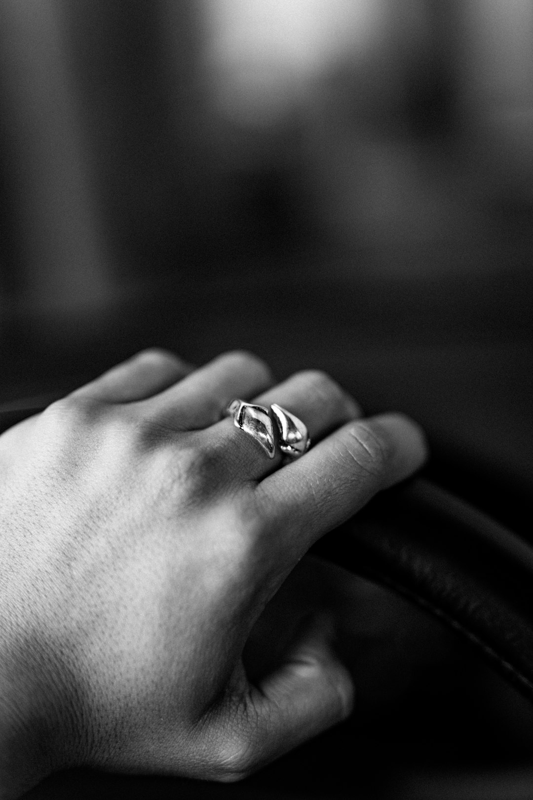 grayscale photo of person wearing silver ring