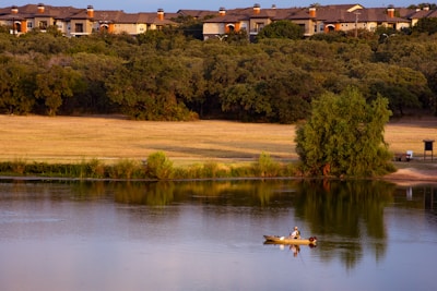A serene morning scene of a bass fisherman casting his line into a calm ranch pond.