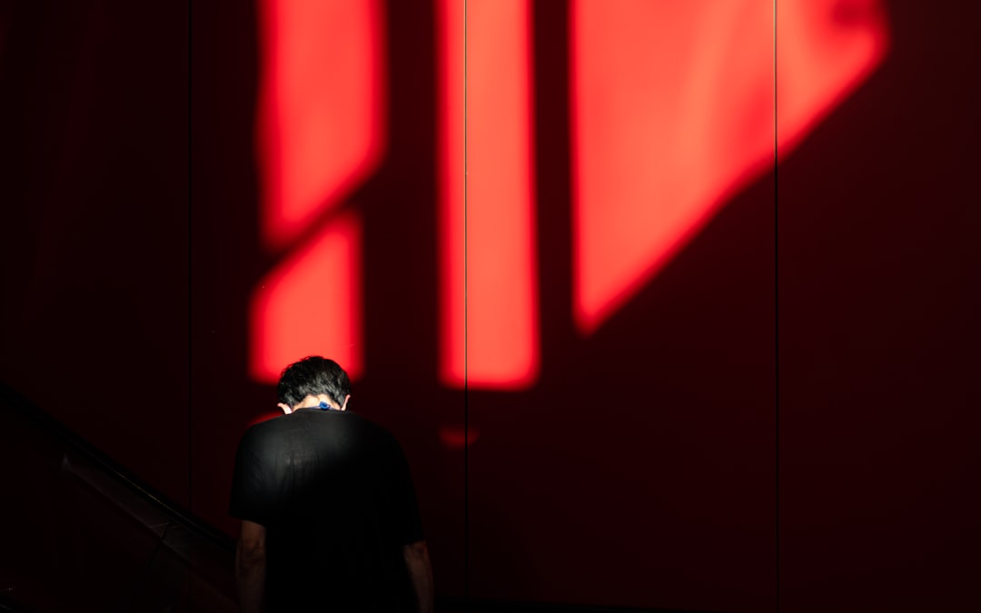 silhouette of man standing near red wall