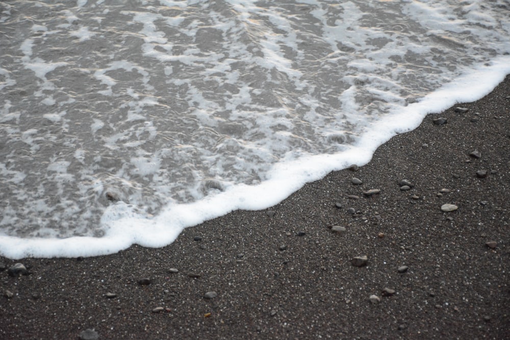 sea waves crashing on shore during daytime