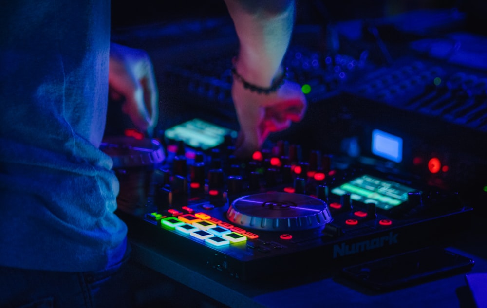 person playing audio mixer with lights