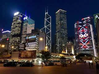 A bustling cityscape with iconic landmarks lit up at night.
