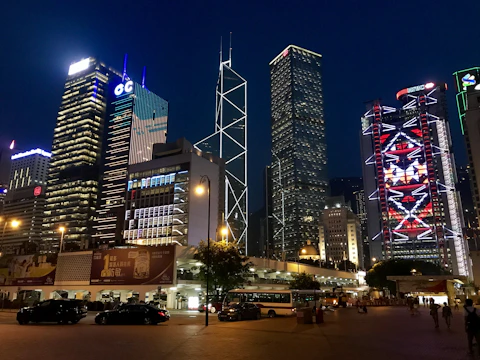 A bustling cityscape with iconic landmarks lit up at night.