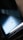 A close-up view of a smartphone's reflective surface, displaying the Xiaomi logo, CE certification, and 5G capabilities with a soft gradient of blue and black tones creating a sleek and modern appearance.