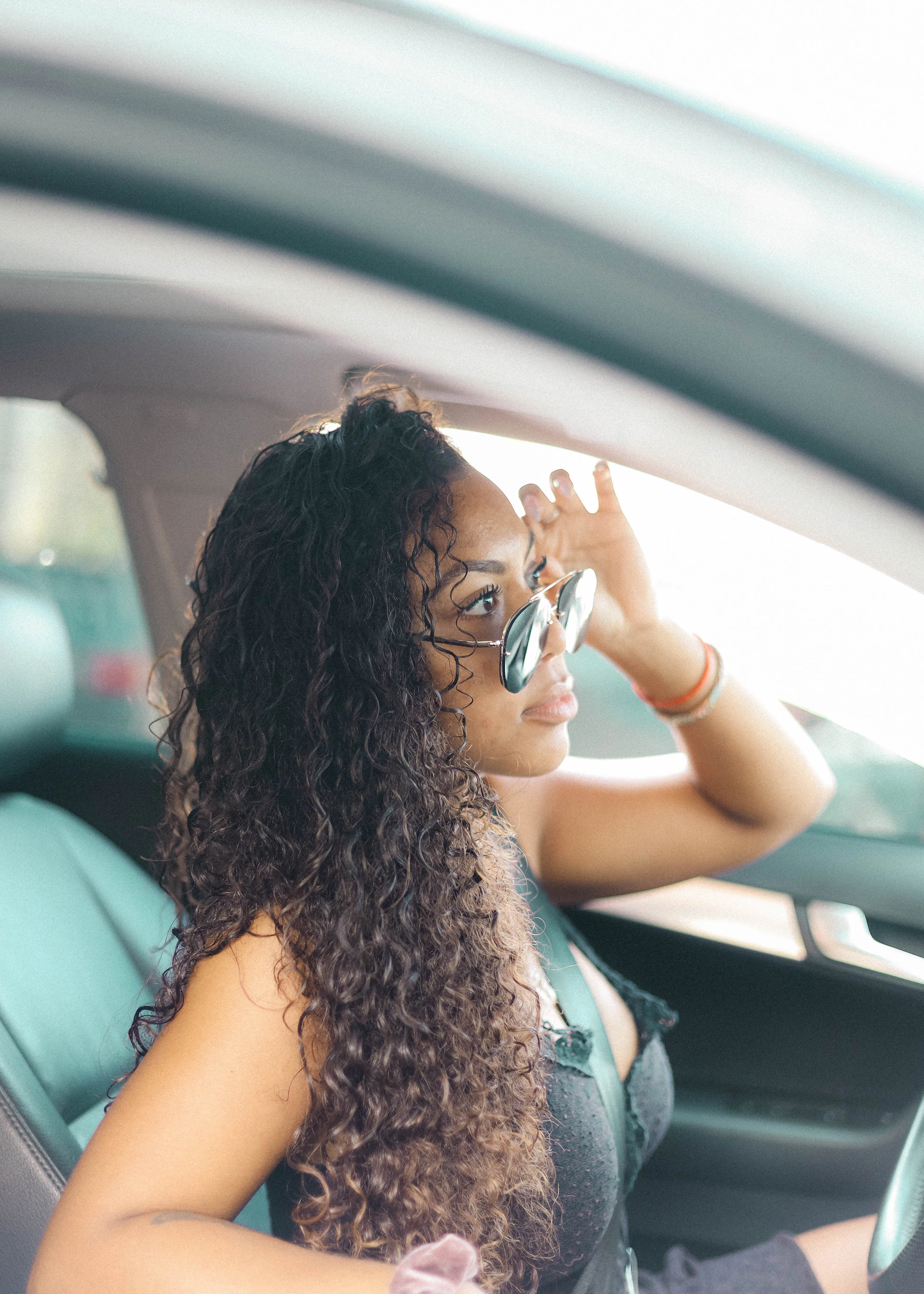 woman in black tank top wearing sunglasses sitting inside car