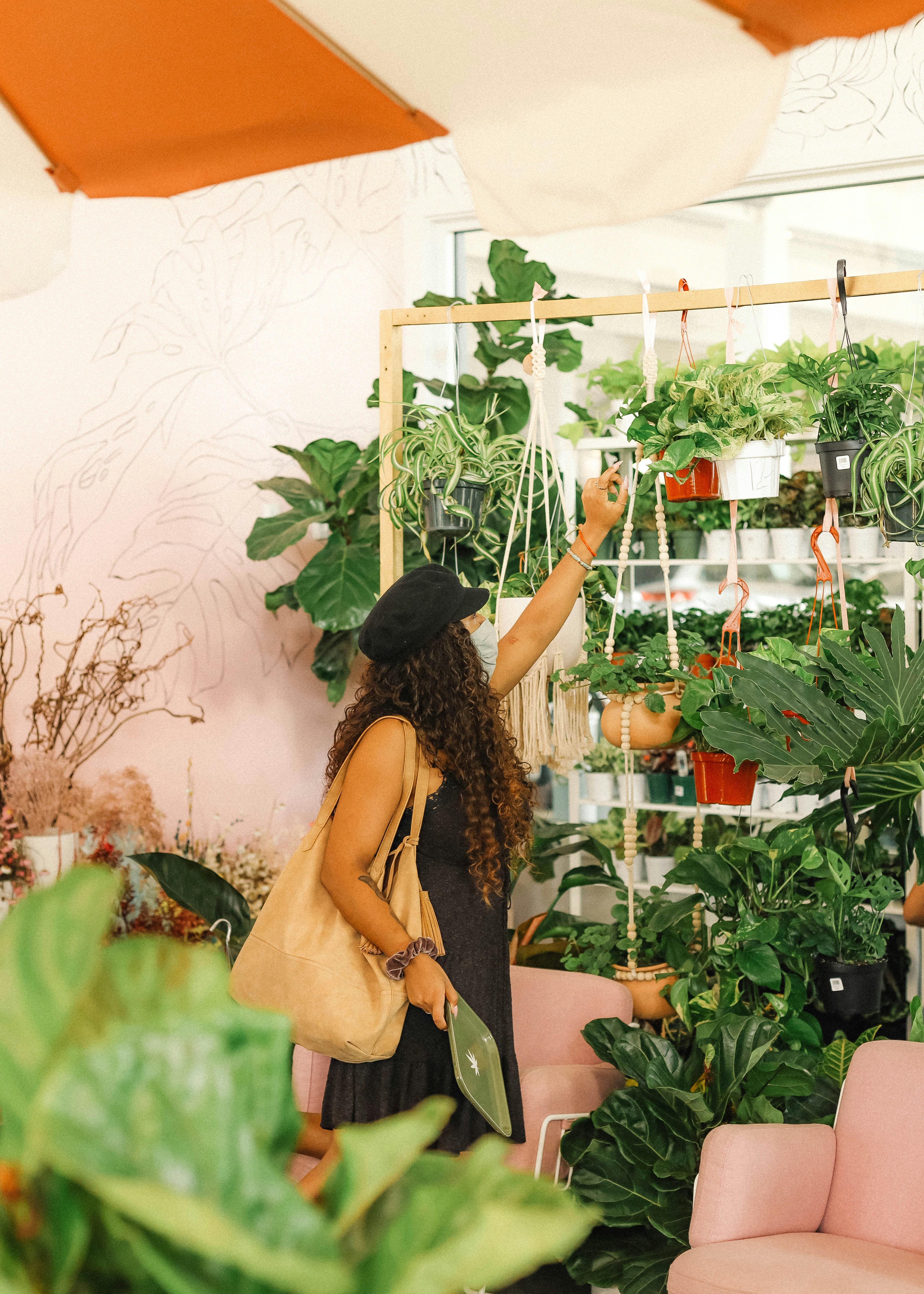 woman in yellow sleeveless dress standing in front of green plants