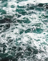 water waves on rocky shore during daytime