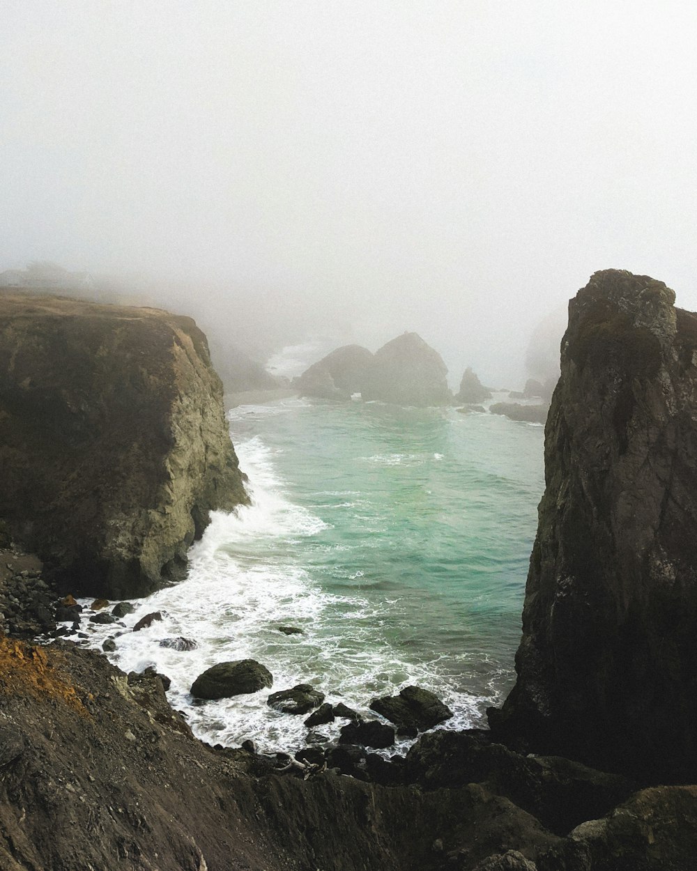 brown rock formation near body of water during daytime