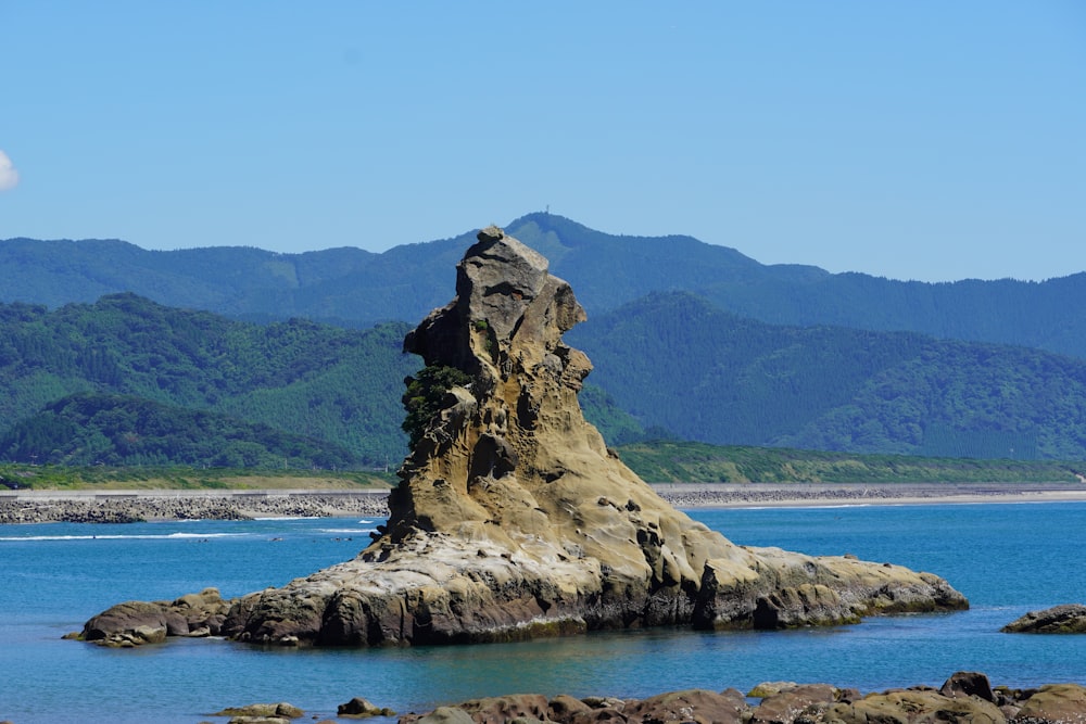 brown rock formation on body of water during daytime