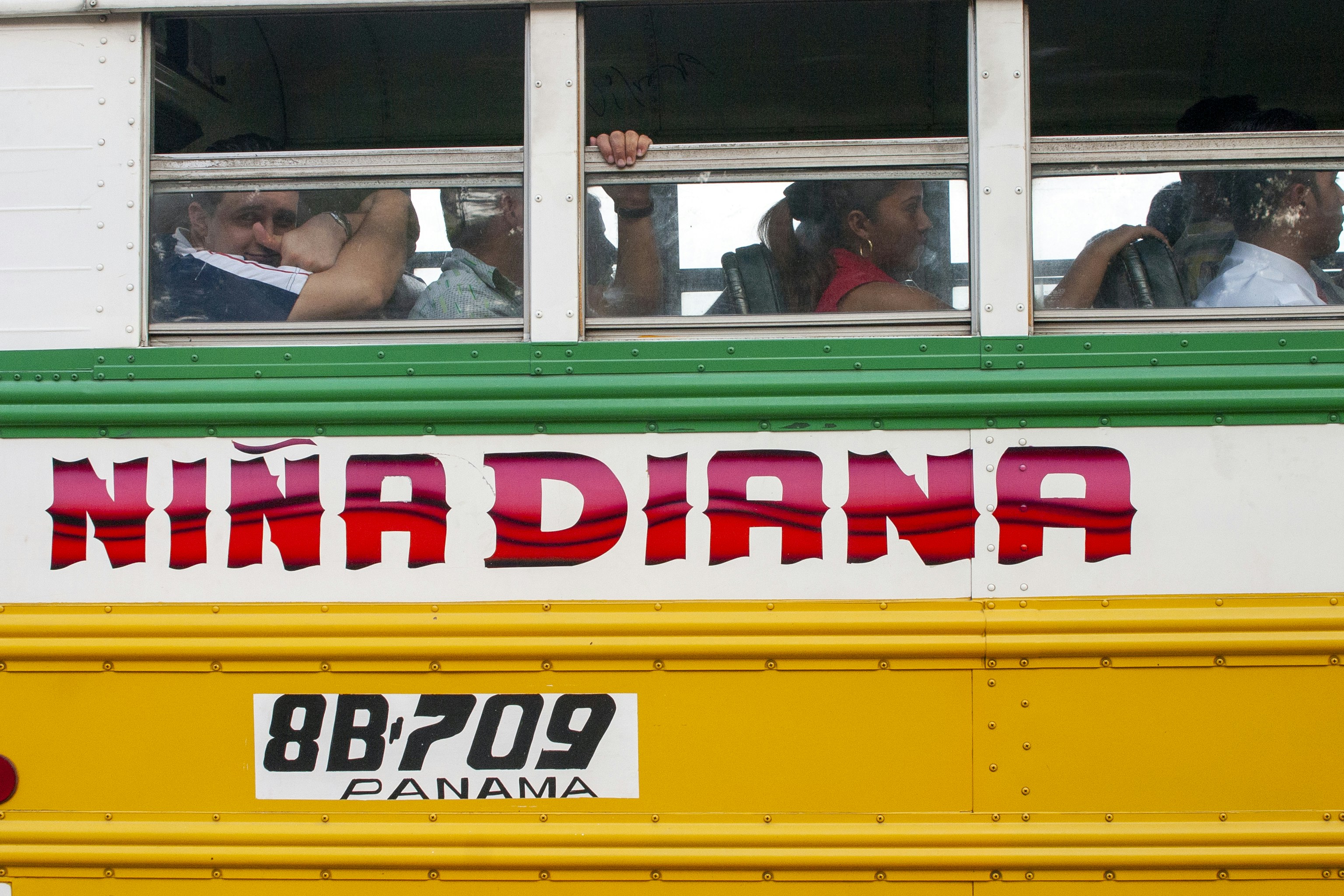 people in yellow and red bus during daytime panama teams background