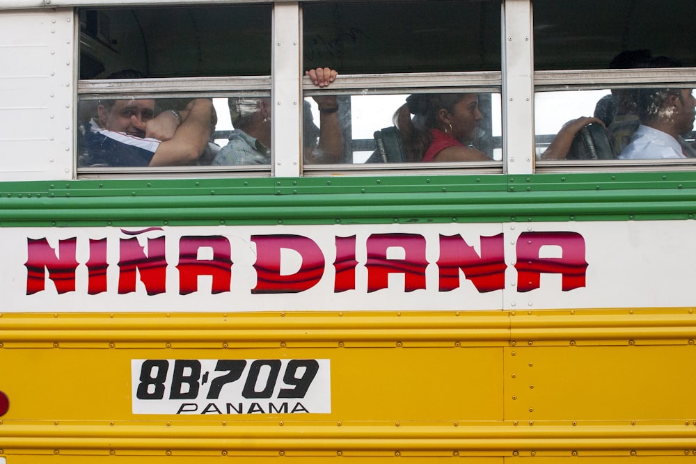 people in yellow and red bus during daytime