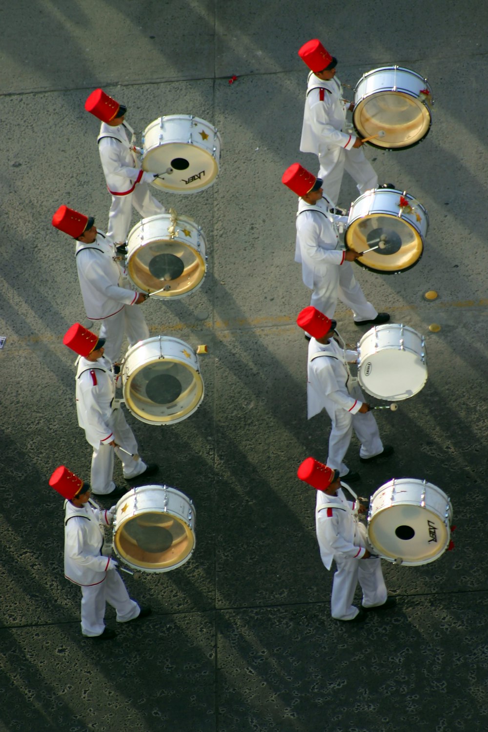 a group of men in white uniforms playing drums