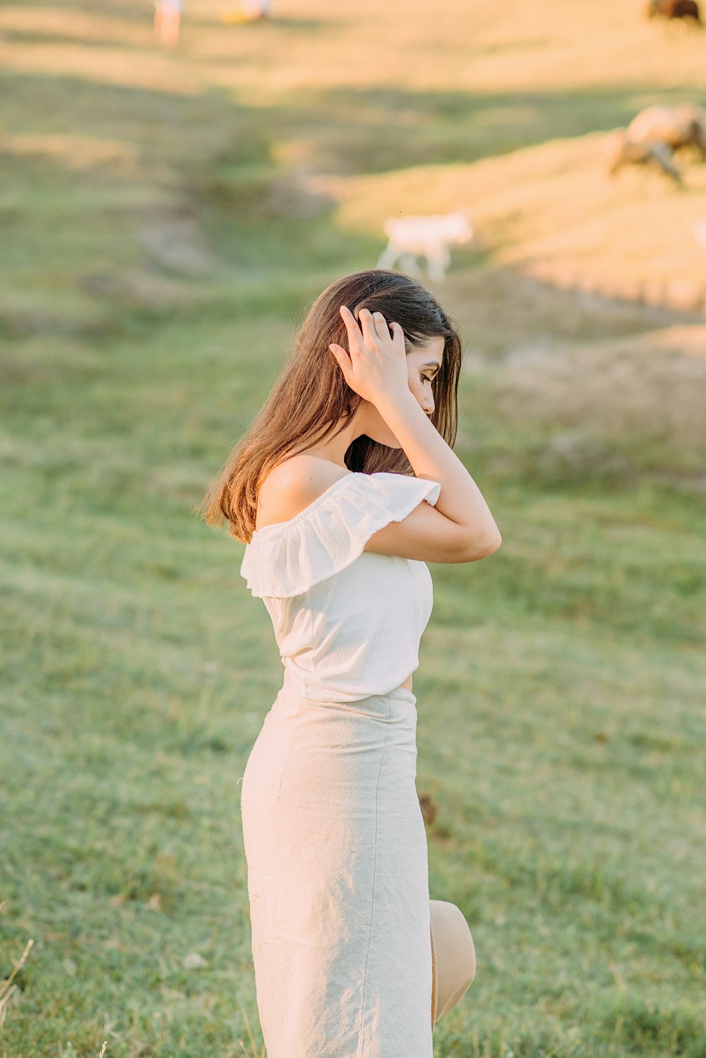 woman in white dress standing on green grass field during daytime