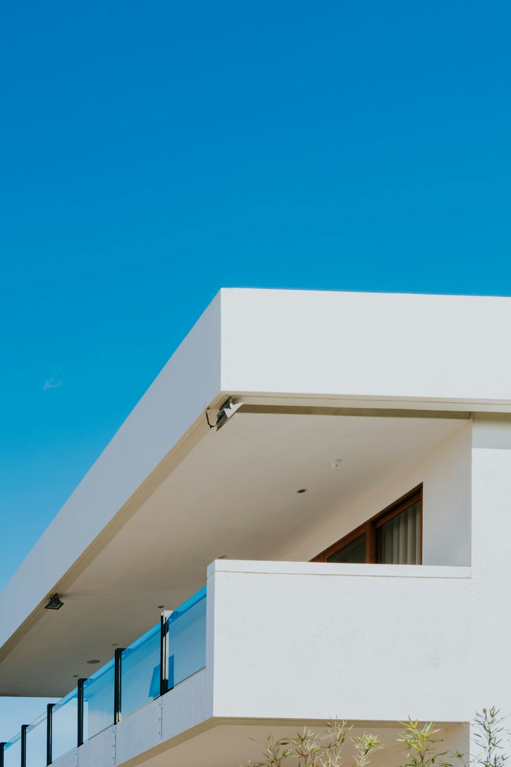 Weißes Betongebäude unter blauem Himmel tagsüber