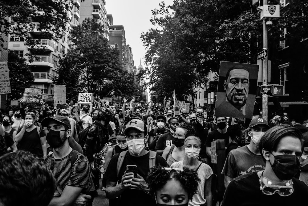 grayscale photo of people in front of trees